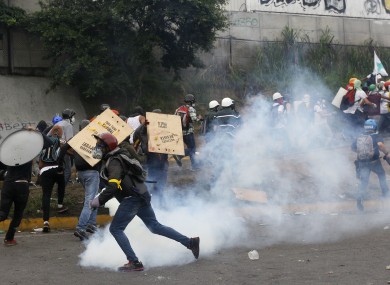 Government forces launching tear gas at demonstrators in Caracas yesterday