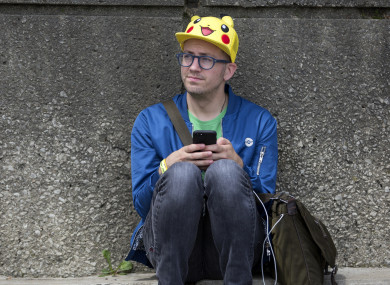 Ryan Copple of Los Angeles sits in the shade as he struggles to play Pokemon Go at the Pokemon Go Fest in Chicago.