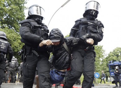 Police officers carry a demonstrator who blocked a street on the first day of the G-20 summit in Hamburg, northern Germany.