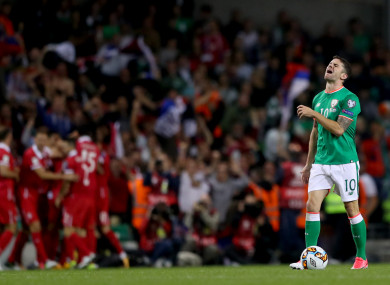 Robbie Brady looking devastated as Serbia celebrate their goal.