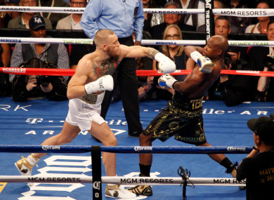 Floyd Mayweather Jr. (L) defends against a punch by Conor McGregor during their super-welterweight bout at T-Mobile Arena in Las Vegas, Nevada.