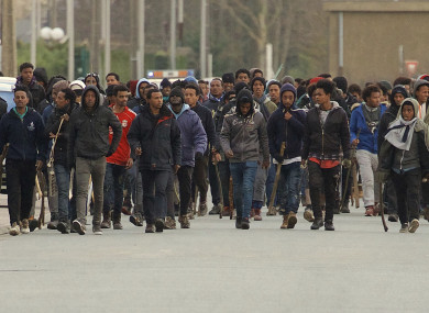 Migrants carrying sticks march in the streets of Calais, northern France, yesterday.