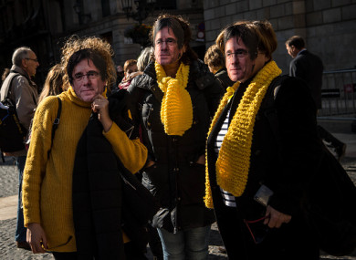 Women wearing cut-out masks of the former Catalan President, Carles Puigdemont pose for a picture, 30 January 2018.