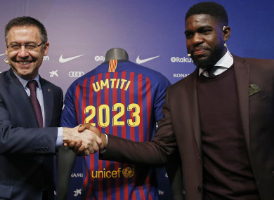 FC Barcelona's Samuel Umtiti, right, shakes hands with FC Barcelona's President Josep Maria Bartomeu during his official announcement of his contract renewal.