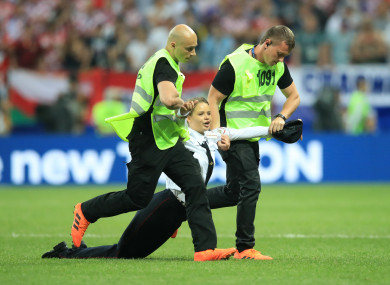 Security staff remove a pitch invader.