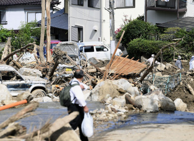 A man walks past debris from a heavy rain in Hiroshima, southwestern Japan
