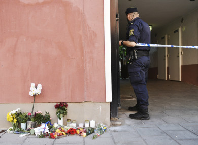 A policeman at the cordon, flowers and condolences outside the place where a 20-year-old man was killed by police.