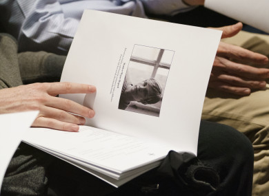 Mourners hold programs with the image of Matthew Shepard.