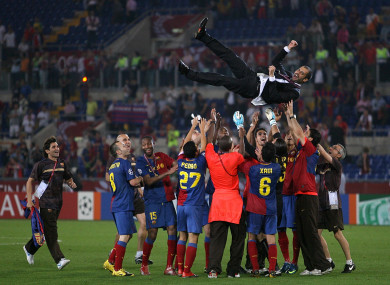 The Barca players fling Guardiola into the air.