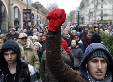 A man with his hand wrapped in a red scarf takes part in a rally in Paris.