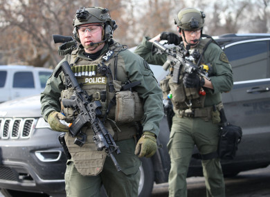 Police officers armed with rifles stage near a building where the shooting took place