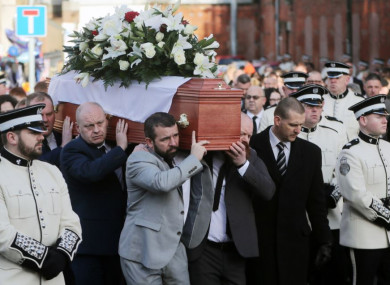 Ian Ogle's coffin is carried past the scene of his murder in East Belfast on Monday.