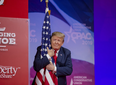US President Donald Trump hugs the US flag during CPAC yesterday.