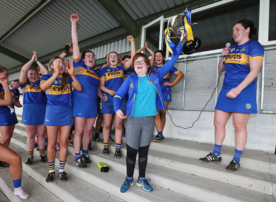 Tipperary celebrate their win with supporter Amy Lillis.