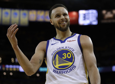 Golden State Warriors' Stephen Curry gestures to fans.