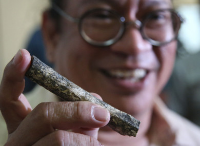 Filipino archeologist Armand Salvador Mijares shows a femur bone discovered in the cave.