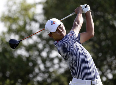 Si Woo Kim hits watches a shot on the 15th hole.