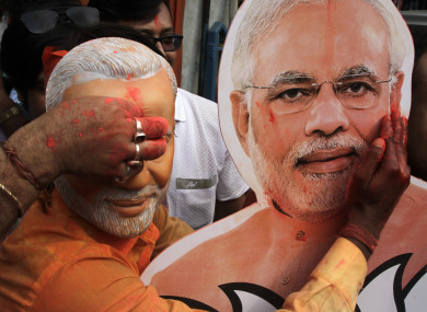 A Bharatiya Janata Party (BJP) supporter puts vermillion powder on a cutout of Narendra Modi during celebrations of the party's victory in Kolkata , India