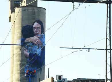 A mural by artist Loretta Lizzio of New Zealand's Prime Minister Jacinda Ardern embracing a woman.