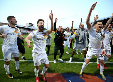 Newport County players and manager Michael Flynn celebrate their win.
