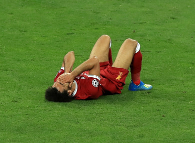 Mo Salah stays on the turf after a tackle from Sergio Ramos.