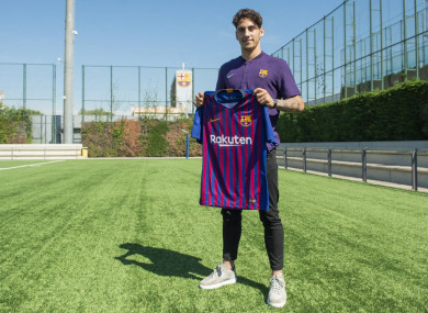 Reis holds up the Barca shirt.