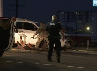 In this image made from video, police proceed to apprehend a suspect on the ground next to a white truck,