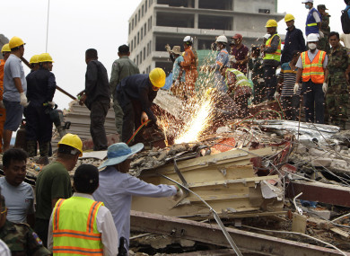 Rescuers try to remove the rubble at the site of the collapsed building.