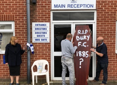 Former director Joy Hart, handcuffed to the main stand, pleads for help to save Bury as fans deliver a symbolic coffin.