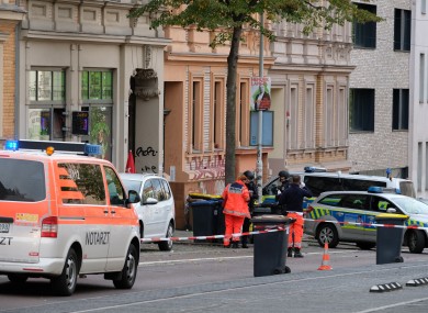 Policemen and rescue workers standing on the street in Halle.