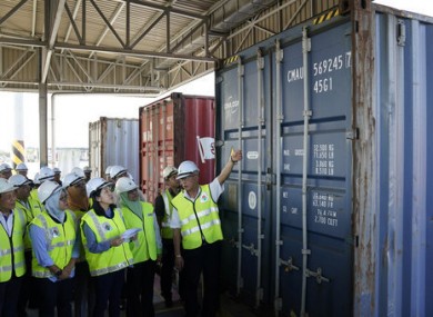 Malaysia’s Environment Minister inspects a container of waste.