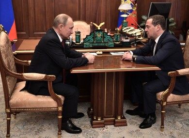 Russian President Vladimir Putin speaks with Russian Prime Minister Dmitry Medvedev.
