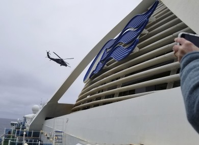 A Coast Guard helicopter delivering virus testing kits hovers above the Grand Princess cruise ship