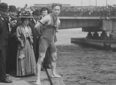 Harry Houdini jumps 30 feet from Harvard Bridge locked up in chains, April 30, 1908. Boston, Massachusetts. His hands were handcuffed and chained to a collar around his neck by a Boston policeman.