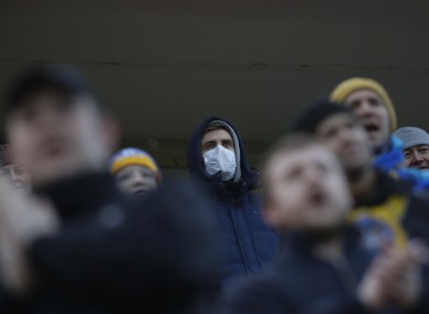 Fans of FC Bate, one of them wearing a face mask, watch on as their team play during the coronavirus pandemic.