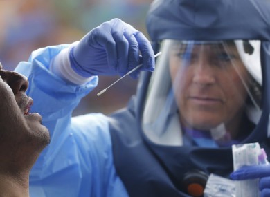 Salt Lake County Health Department public health nurse Lee Cherie Booth performs a Covid-19 test.