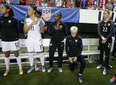 Megan Rapinoe knees next to team-mates before a game between USA and Netherlands in September 2016.