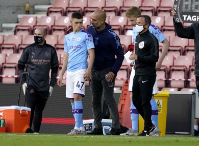 Man City manager Pep Guardiola giving Phil Foden instructions before his introduction.