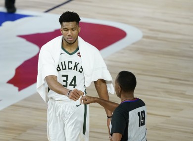 Milwaukee Bucks' Giannis Antetokounmpo (34) fist bumps referee James Capers (19).