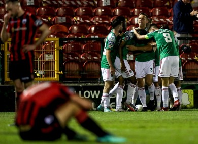 Longford slump in dejection as Cork celebrate their winning goal.