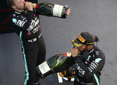 Race winner, Mercedes driver Lewis Hamilton of Britain, front, drinks champagne with third placed Mercedes driver Valtteri Bottas of Finland.