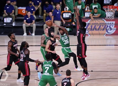 Boston Celtics guard Marcus Smart (36) passes the ball out as Miami Heat's Bam Adebayo, right, blocks the path to the net.