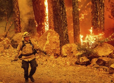 A firefighter walks a path as the Glass Fire burns along Highway 29 in Calistoga, California