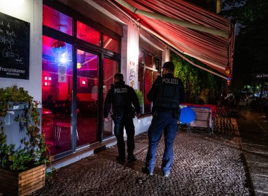 Pictured are two Berlin policemen checking that the curfew is observed in the Friedrichshain district, 14 October.