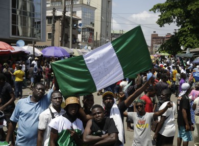 People hold banners as they demonstrate on the street to protest against police brutality, in Lagos