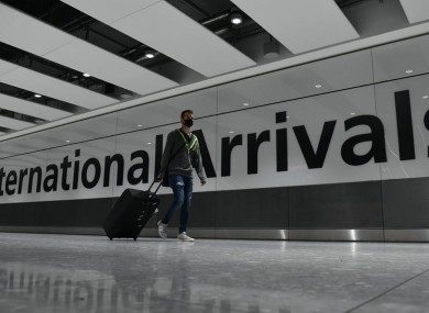 Passenger wearing face mask walking through Heathrow.