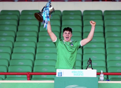 Limerick's Adam English lifts the trophy at the end of the game.