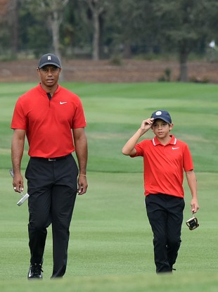Tiger Woods and his son Charlie approach the 18th green.