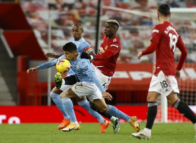 Manchester City's Fernandinho and Rodri battle with Manchester United's Paul Pogba
