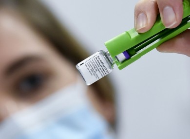 A health worker inspects vials of the Pfizer-BioNTech Covid-19 vaccine as they are thawed in a lab in Leuven, Belgium.